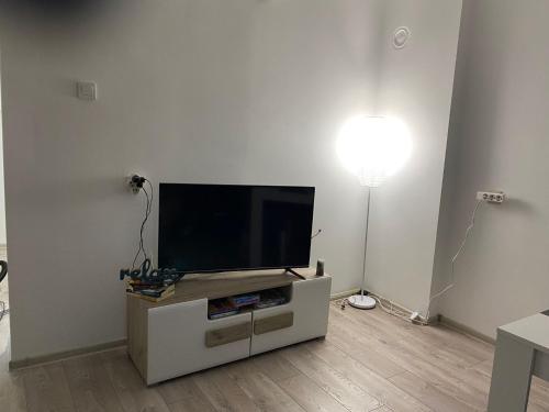 a flat screen tv sitting on a stand in a living room at Apartman Jorgos in Soko Banja