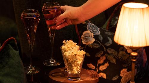 a person holding a glass of wine next to two wine glasses at The Montenotte Hotel in Cork