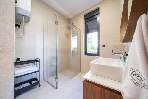 a bathroom with a sink and a glass shower at C Group apartments in Kotor