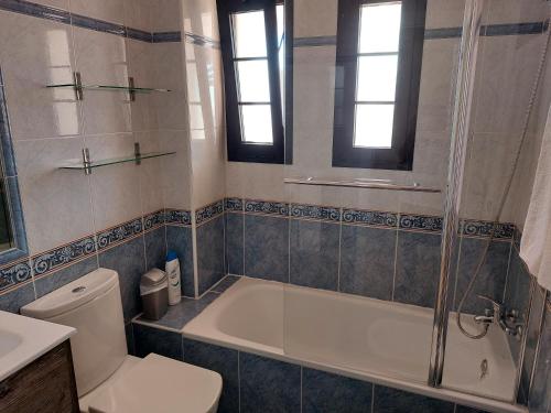 y baño con bañera, aseo y lavamanos. en Villa Real Oliva, en Corralejo