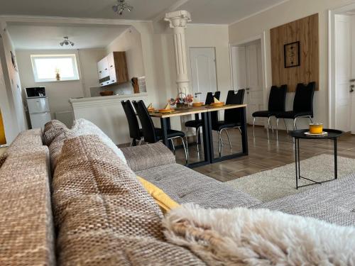 a living room with a couch and a table with chairs at Négy Évszak Vendégház in Aggtelek