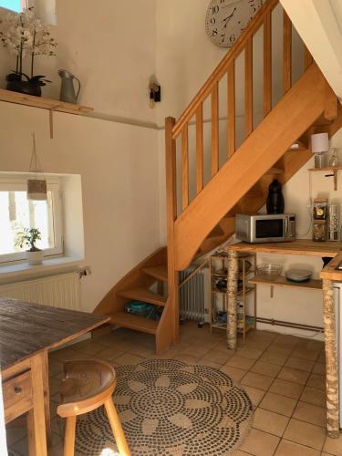 une cuisine avec un escalier en bois et une table dans l'établissement le hameau de Sylvanes, à Sylvanès