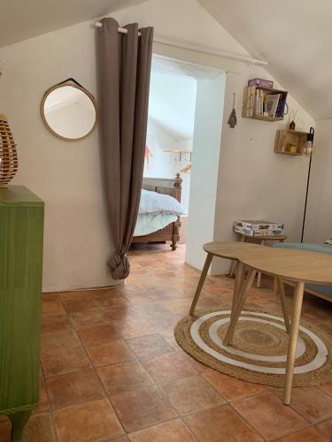un salon avec une table et une chambre dans l'établissement le hameau de Sylvanes, à Sylvanès
