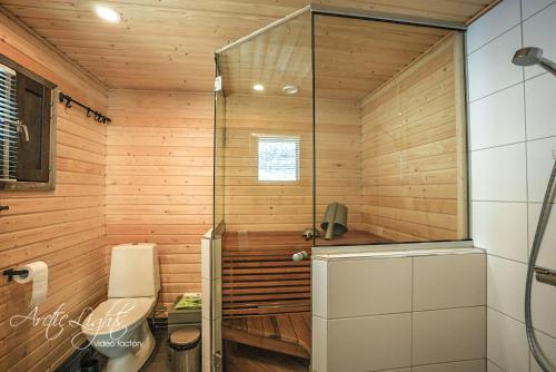 La salle de bains est pourvue d'une douche avec une porte en verre. dans l'établissement Aava Sky Village, à Aavasaksa