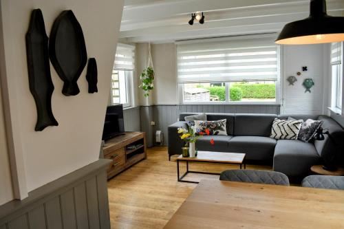 uma sala de estar com um sofá e uma mesa em Naar de kust em Hollum