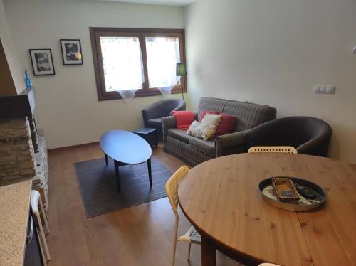 a living room with a couch and a table at Los Altos de Escarrilla - tucasaenlospirineos in Escarrilla