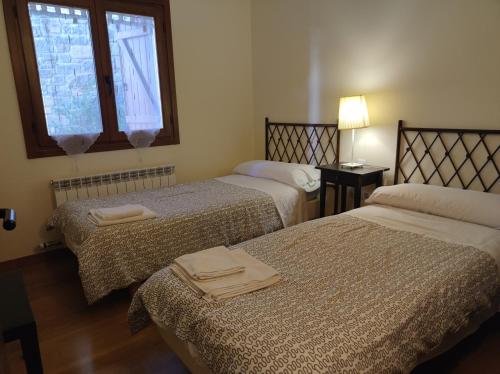 a room with two beds and a window at Los Altos de Escarrilla - tucasaenlospirineos in Escarrilla
