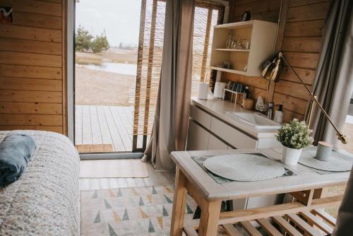 una camera con letto, tavolo e lavandino di Vienkiemio oazė - Skandinaviškas namelis su vaizdu į tvenkinį a Galvokai