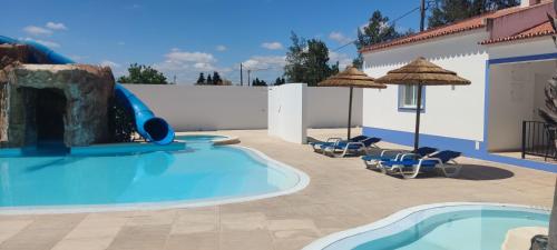 a pool with a water slide in a backyard at Casa Almeida in Vimieiro