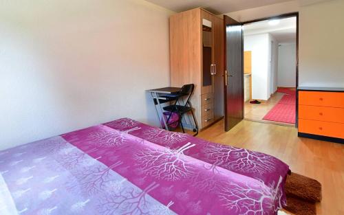 a bedroom with a pink bed and a hallway at House Luna in Rakovica