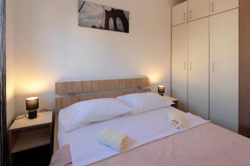 um quarto com uma cama com duas toalhas em Central Apartment with Jacuzzi em Novalja