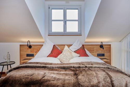a bedroom with a large bed with red pillows at Landhotel Schneider in Riedenburg