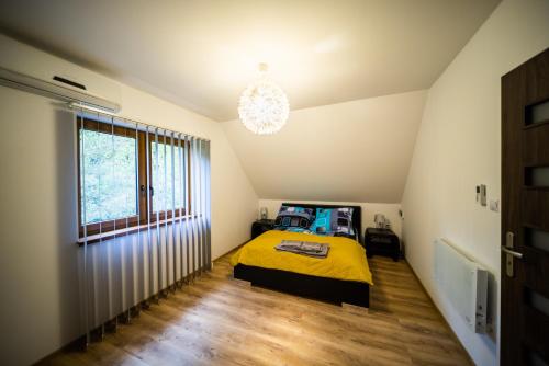 a bedroom with a yellow bed and a window at Domek w Sosenkach in Osłonin