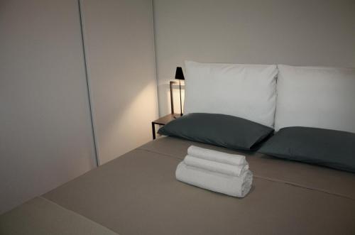 1 dormitorio con 1 cama con toallas en Appartamento Signorile, en Cagliari