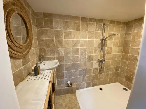 y baño con bañera, lavamanos y ducha. en Villa Verde - Gîte - possibilité table d'hôte, en Boisseron