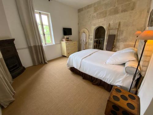 ein Schlafzimmer mit einem großen Bett und einem Kamin in der Unterkunft Villa Verde - Gîte - possibilité table d'hôte in Boisseron