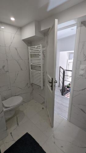 La salle de bains blanche est pourvue de toilettes et d'un escalier. dans l'établissement Appartement T3 , 650m du Palais des Festivals, à Cannes