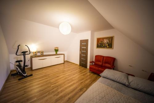a attic room with a bed and a red chair at Domek w Sosenkach in Osłonin