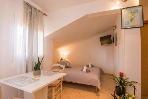 a small room with a bed and a table at Apartments City Center Dekanić in Krk