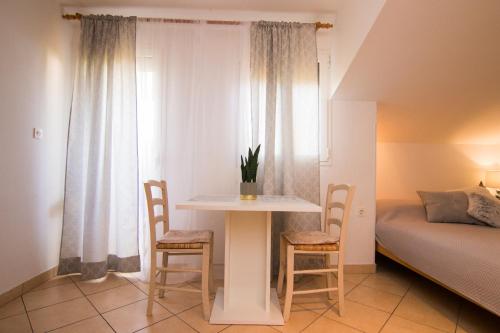 - une chambre avec une table, deux chaises et un lit dans l'établissement Apartments City Center Dekanić, à Krk