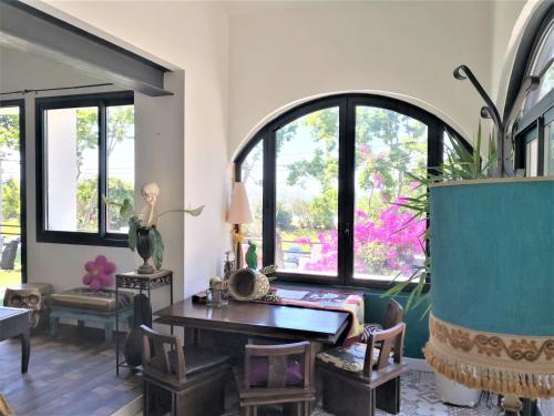 a living room with a table and chairs and windows at Marseille-au-bord-de-l'eau in Marseille