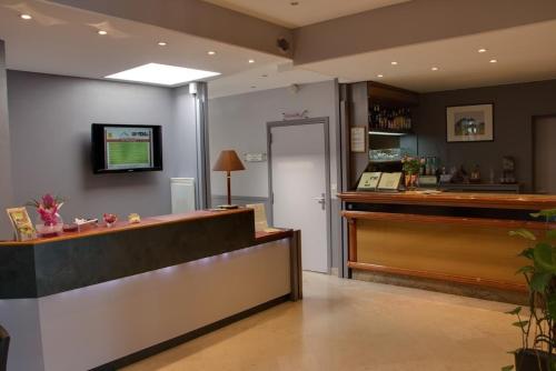 a salon with a cash register and a counter at Hotel Restaurant l'Amandois in Saint-Amand-Montrond