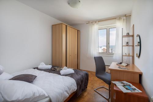 a bedroom with a bed and a desk and a chair at Apartment Lucy in Split in Split
