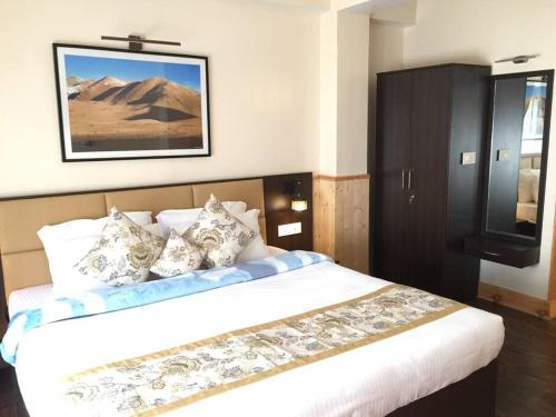 1 dormitorio con 1 cama grande y TV en la pared en Green Tara Homestay en Gangtok