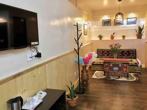 een woonkamer met een bank en een tv bij Green Tara Homestay in Gangtok