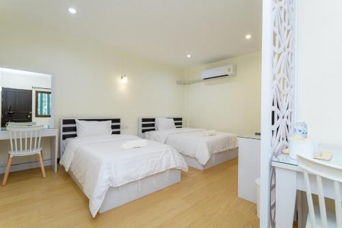 Cet appartement comprend une chambre avec deux lits, un bureau et une cuisine. dans l'établissement Thai Guest House, à Ban Don Klang