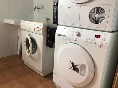 een wasmachine en een droger in de badkamer bij O Solpor Fillobal in Vilar