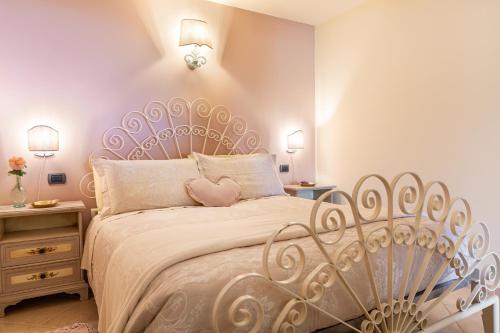 1 dormitorio con cama blanca y cabecero cardiaco en Agriturismo L’Orto di Muma en Gorleri