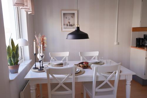 Frost Longstay Sundellsgatan 3 C في هاباراندا: غرفة طعام مع طاولة بيضاء وكراسي