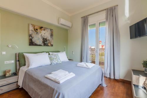 Un dormitorio con una cama con toallas blancas. en Renaissance Apartment, feeling the heartbeat of Rethymno!, en Rethymno