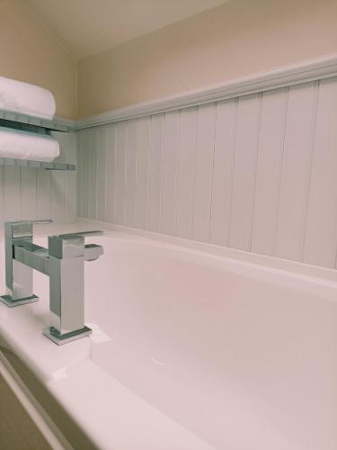 a bathroom with a bench and a sink at The Gwaelod y Garth Inn in Cardiff