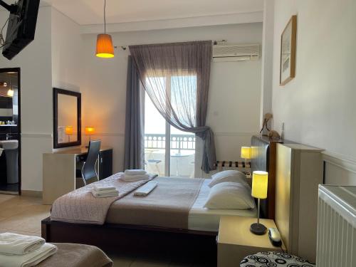 ein Schlafzimmer mit einem großen Bett und einem Fenster in der Unterkunft Galini Hotel in Pefki