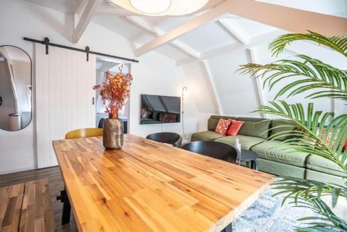 a living room with a wooden table and a couch at Casa Coral - a hidden gem for families in Groningen