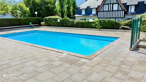 een zwembad in een tuin met een huis bij Escapade marine à 'l'Abri Côtier' in Deauville