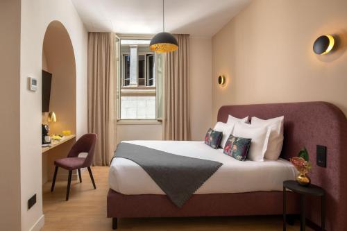 una camera d'albergo con letto e scrivania di 9Hotel Cesari a Roma