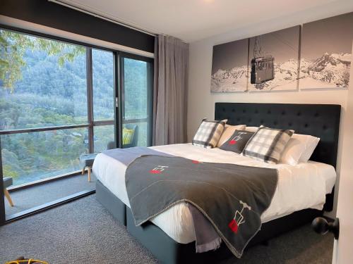 スレッドボにあるTyrola Eleven Thredboの大きなベッドと大きな窓のある寝室