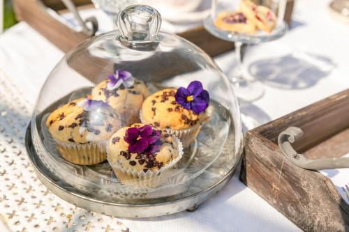 a glass dish with cupcakes in it on a table at Agriturismo L’Orto di Muma in Gorleri