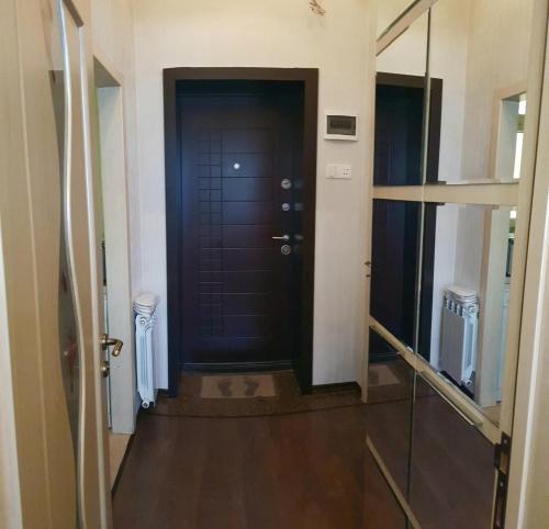 バクーにあるCentral Baku Luxury Apartment on Nizami Streetの黒いドアと木製の床の廊下