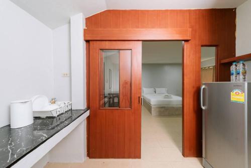 a kitchen with a wooden door and a refrigerator at Baan Gatto in Khao Lak