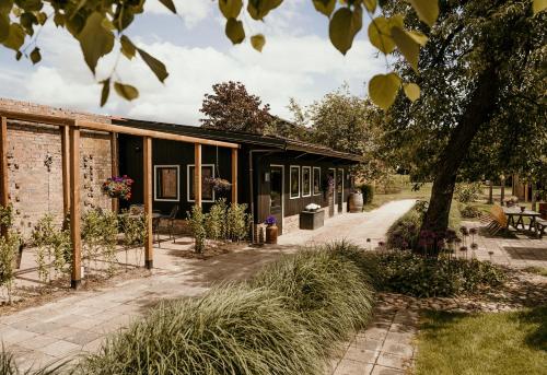 a house with a black facade and a sidewalk at In de tuin in Gees in Gees