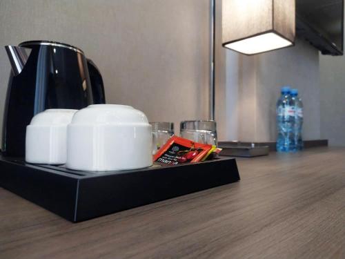 a coffee pot and glasses sitting on a counter at Vinum Hotel in Tbilisi City