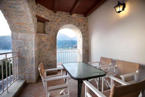 a balcony with a table and chairs and a window at Traditional Apartments Plagiaki in Neon Oitilon