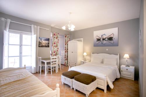 a bedroom with a white bed and a table and chairs at Traditional Apartments Plagiaki in Neon Oitilon