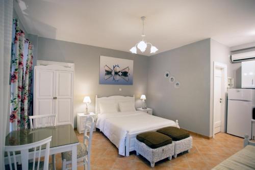 a bedroom with a white bed and a kitchen at Traditional Apartments Plagiaki in Neon Oitilon
