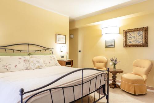 a bedroom with a bed and two chairs at Agriturismo L’Orto di Muma in Gorleri