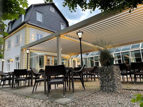 a table and chairs in front of a building at Hotel-Gasthof Hüttensteinach in Sonneberg